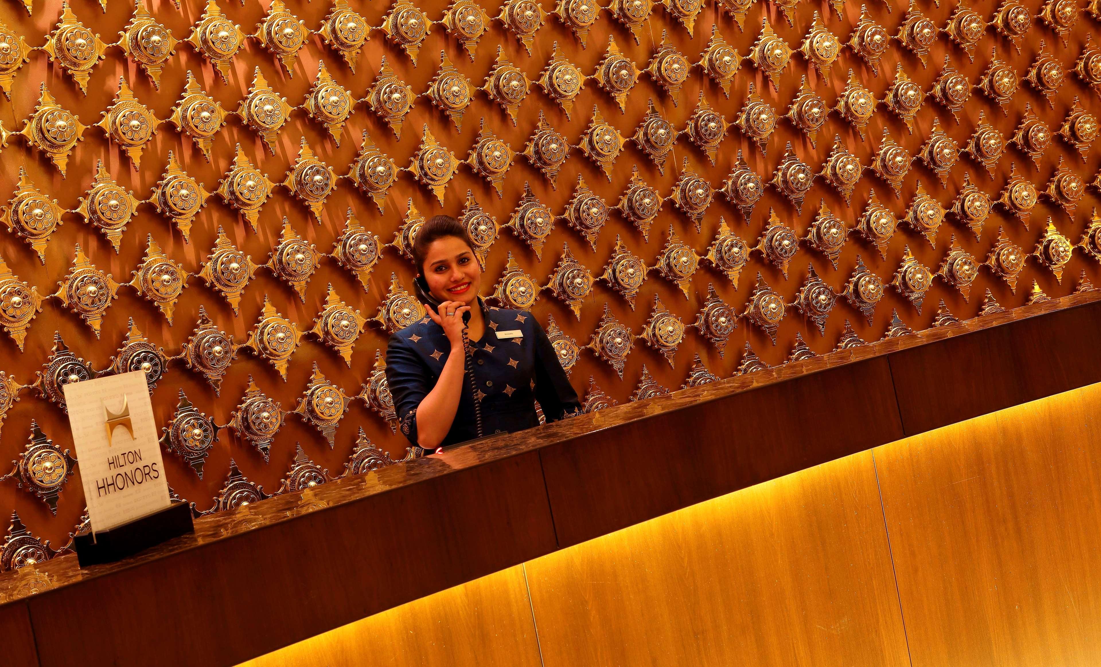 Hilton Jaipur Hotel Екстериор снимка A hotel receptionist at work